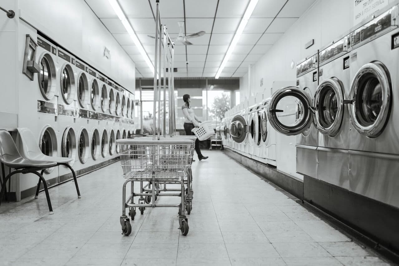 Zwart-witfoto van een wasserette met rijen wasmachines
